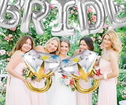 Bride posing in front of silver BRIDE balloons
