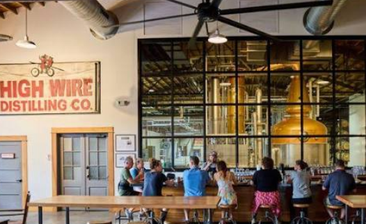 Copper stills and barrel wall at High Wire Distilling