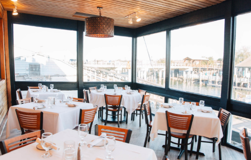 Bachelorette group sharing seafood and cocktails on a Shem Creek deck
