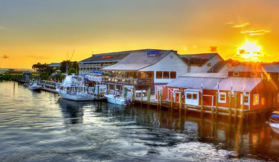 Bachelorette group on a deck over Shem Creek in Mount Pleasant at sunset